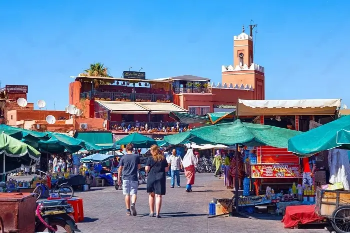 Couple exploring the vibrant Djemaa el Fna square in Marrakech on their Morocco honeymoon