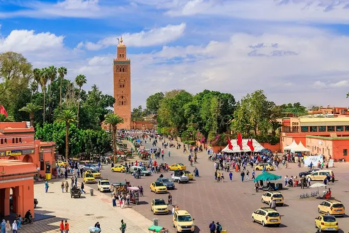 Aerial view of the bustling Jemaa el Fna plaza and the iconic Koutoubia Mosque minaret in Marrakech during a 2 weeks in Morocco tour