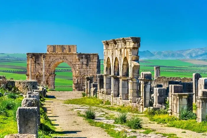 The ancient Roman ruins and Arch of Caracalla at the UNESCO listed site of Volubilis on a two weeks in Morocco itinerary