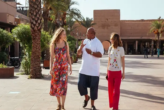 Tourists exploring the Marrakech Medina with a local guide during an 8 day tour from Casablanca